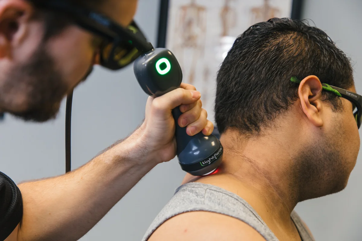 Clinician and patient wearing protective eyewear during a LightForce neck application